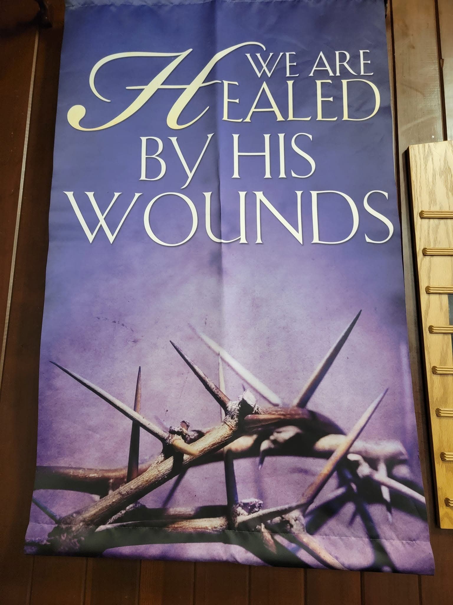 A Lenten banner hanging in the sanctuary: “We are healed by his wounds,” above a crown of thorns