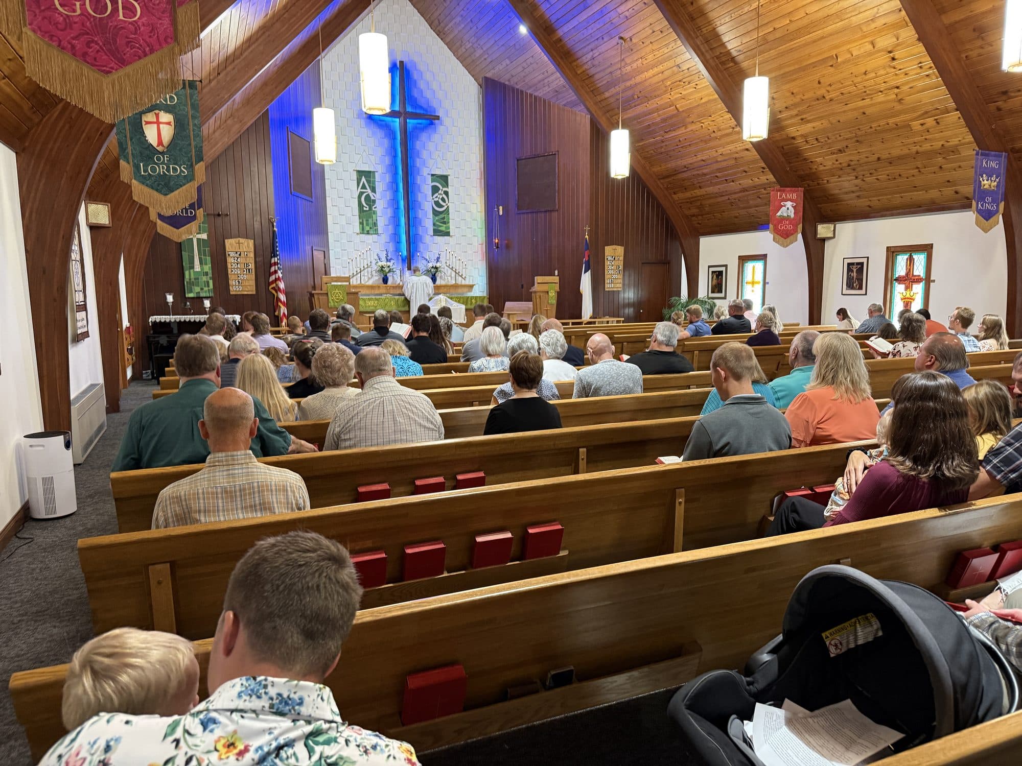 The nave from the back pew during worship, with the congregation seated and hymnals open